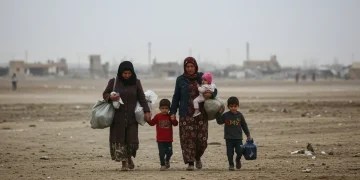 Displaced family walks through war-torn landscape, symbolizing humanitarian cost of regional conflicts